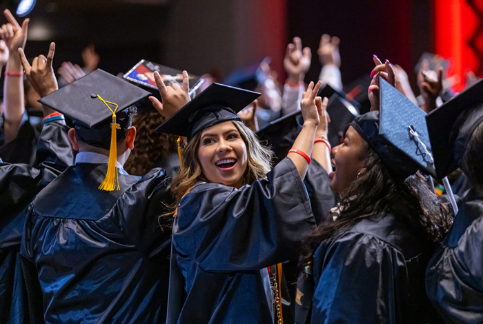 Group of graduates in caps and gowns celebrates at ceremony