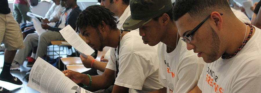 Students in the 100 Males to College program in Springfield read a packet at Westfield State University